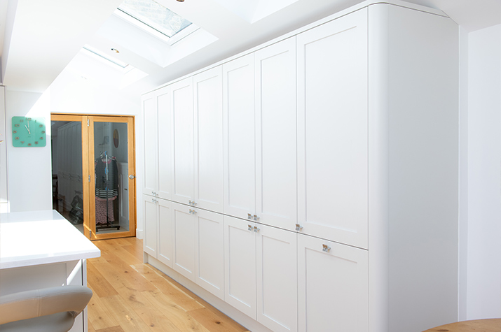 white kitchen storage with wooden table