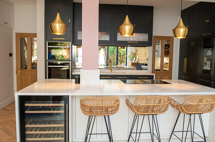 kitchen with a view to the kitchen island, chairs and oven