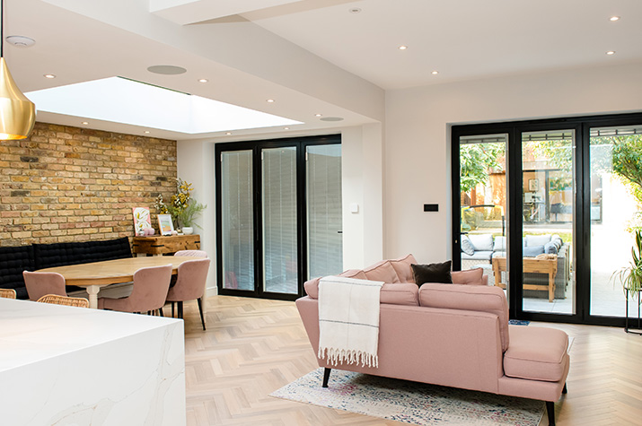 side view of living room with pink sofa and dining table