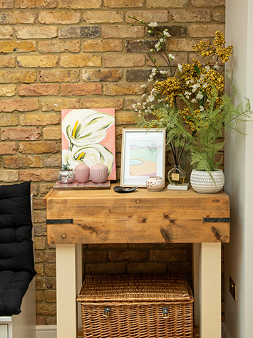 decorated wooden table with basket placed under it